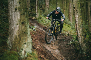 Privateer rider on full suspension Ohlins bike shredding trail
