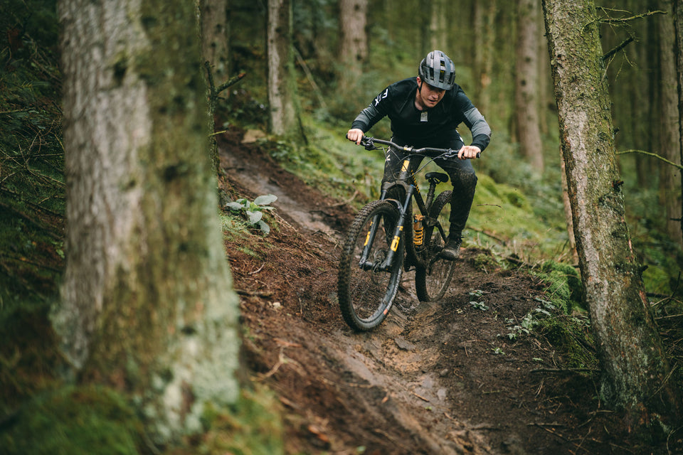 Privateer rider on full suspension Ohlins bike shredding trail